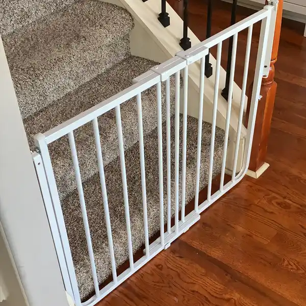 The Cardinal Gates Stairway Special Safety Gate securely installed at the top of a staircase, preventing access and ensuring the safety of young children. The gate’s robust construction and reliable mounting make it a top choice for babyproofing stairways and maintaining home safety.