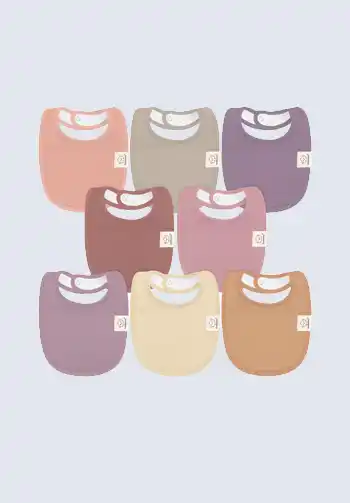 A set of colorful bibs in shades of pink, purple, and brown, perfect for protecting your baby's clothes from spills and drools, essential for your diaper bag.