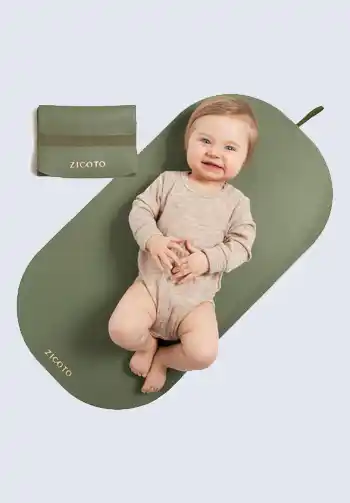 An olive green portable changing pad with a baby lying on it, offering a comfortable and compact solution for diaper changes, essential for your diaper bag.