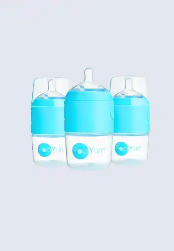 A set of Comotomo baby bottles with blue silicone sleeves, known for their soft, skin-like feel and wide mound, great for feeding while on the go, perfect for your diaper bag.