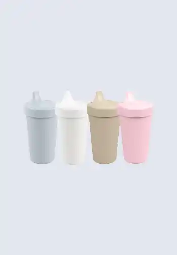 A set of assorted silicone baby bottles in gray, white, tan, and pink, great for convenient feeding while on the go, perfect for your diaper bag.