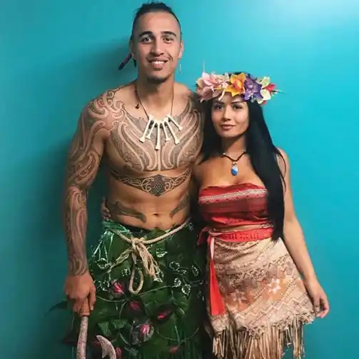 A couple dressed as Moana and Maui, showcasing their detailed and matching Halloween costumes.