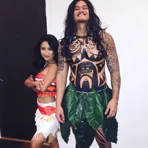  A couple wearing Moana and Maui costumes, highlighting their coordinated and creative Halloween outfits.