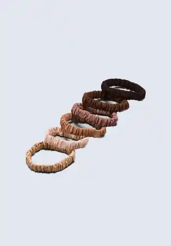 A set of brown and beige hair ties, perfect for keeping hair out of your face during labor, an essential item for a hospital bag list for birth.