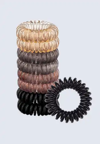 A stack of spiral hair ties in various neutral colors, perfect for avoiding hair creases during labor, making them a necessary item for a hospital bag for delivery list.