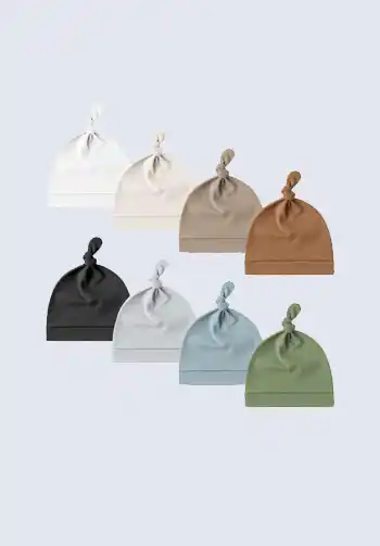 A set of neutral baby hats and mittens in various colors, perfect for keeping your newborn warm. A must-have item on your hospital bag checklist.