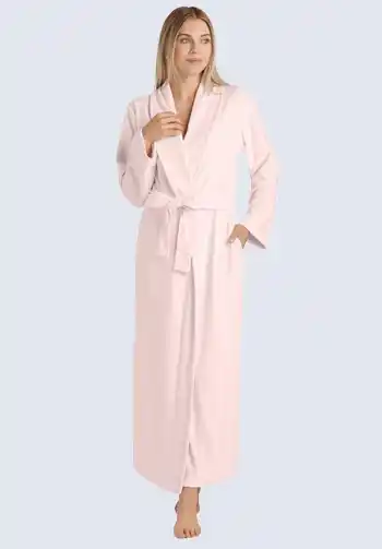 A woman in a long, light pink robe with a tie waist, offering comfort and coverage, making it an important item for a hospital bag for mom and postpartum recovery.