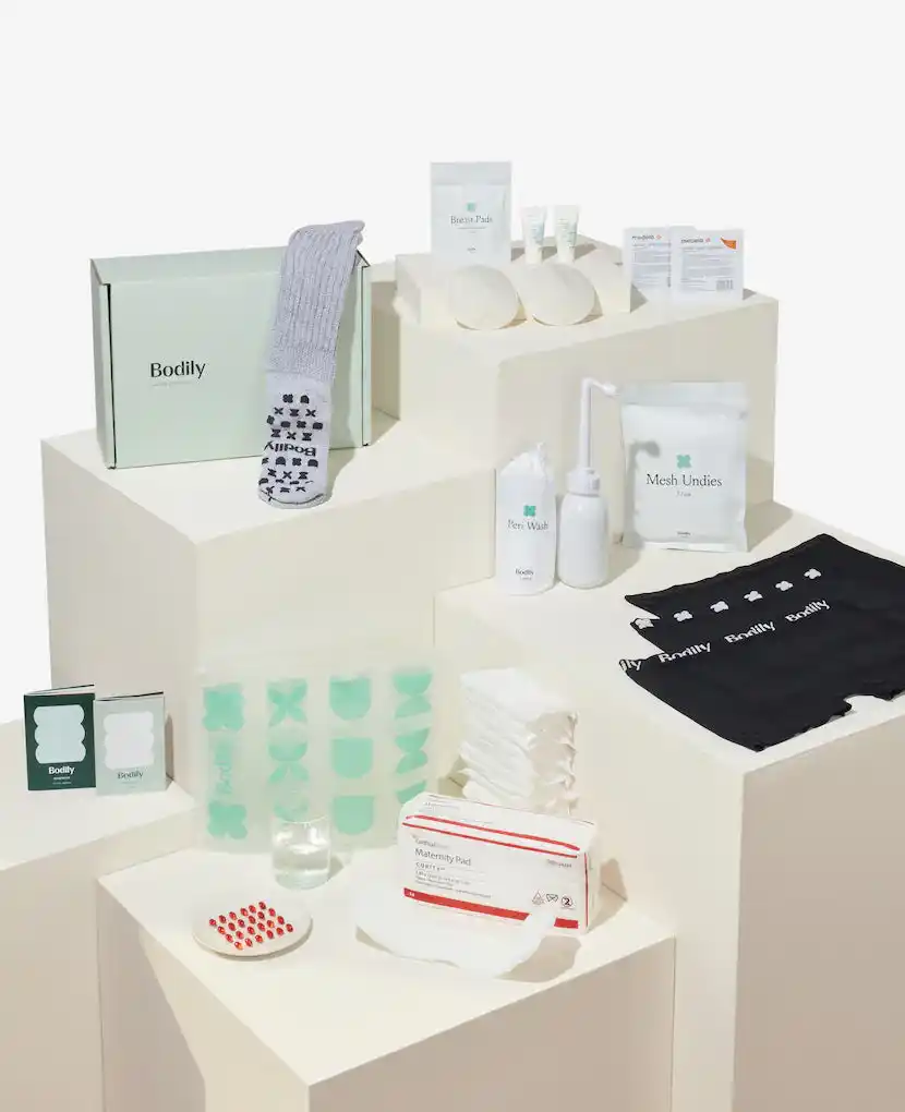 The Bodily Care for Birth Box, featuring postpartum essentials such as nursing pads, peri wash bottle, mesh underwear, maternity pads, and cozy socks, perfect for creating a comprehensive postpartum gift basket.