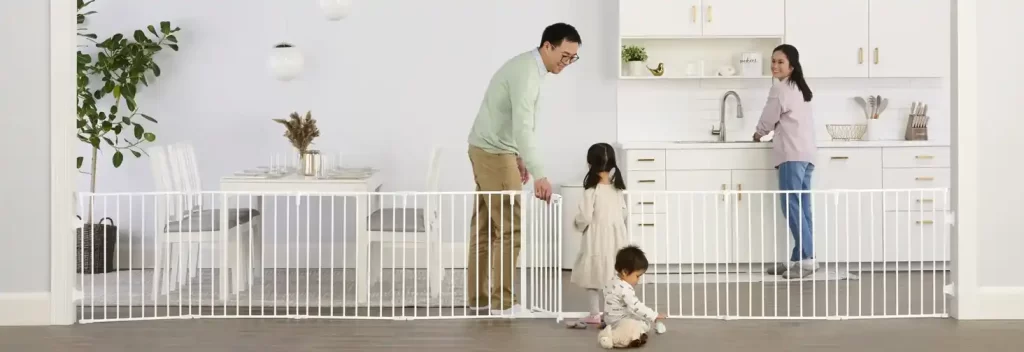 A family using the Regalo Super Wide Baby Gate and Play Yard to create a safe play area in their home. The gate extends across a wide doorway, showcasing its ability to cover large openings up to 192 inches. This versatile childproof gate can be configured into various shapes, providing a secure and flexible barrier for your little explorer. Ideal for babyproofing open floor plans and creating safe play spaces, this best safety gate blends functionality with convenience, ensuring peace of mind for parents.