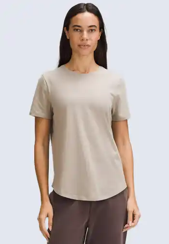 This neutral beige short-sleeve tee is perfect for the layered up soccer mom wear. Its soft fabric and versatile color make it an ideal base layer for cooler game days. Pair it with a cozy cardigan or jacket for a comfortable and stylish soccer mom outfit.