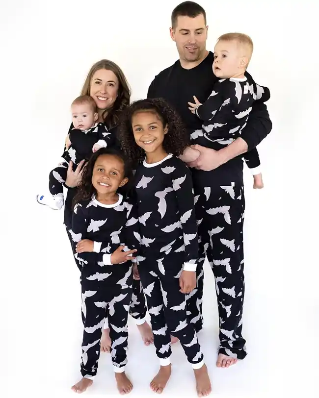 Family wearing matching family Halloween pajamas with a bat pattern, creating a spooky and stylish look for Halloween festivities.