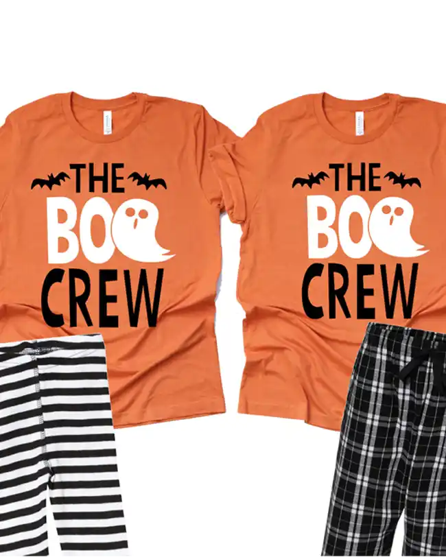 Matching family pajamas with orange tops featuring 'The Boo Crew' slogan and ghost graphic, paired with striped and plaid bottoms, perfect for a fun and festive Halloween celebration.