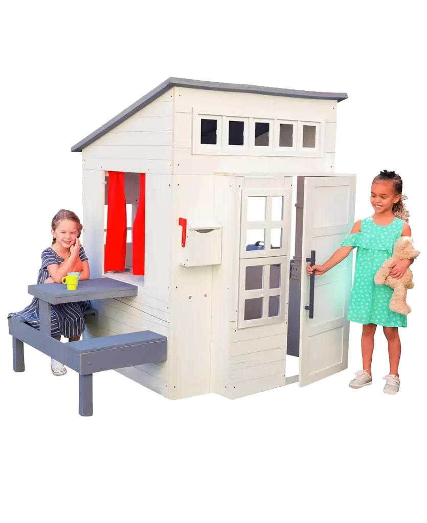 KidKraft Modern Outdoor Playhouse with two children playing, featuring a mailbox, picnic table, and red curtains.