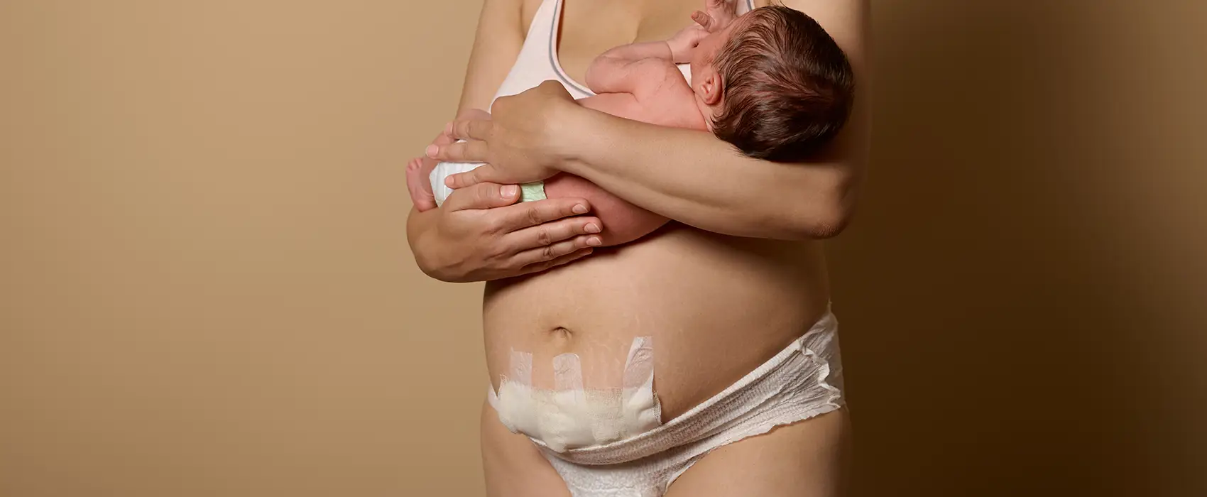 A new mom holding her baby, showcasing the bond and recovery process after a c-section delivery.