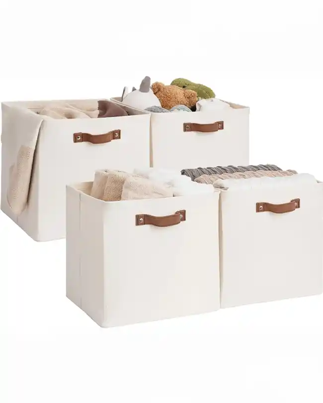 A set of fabric storage bins with sturdy handles, filled with toys and blankets, providing a soft and portable toy storage solution.