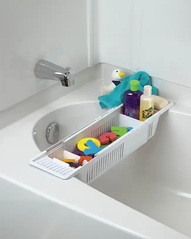 A bath toy organizer tray spanning the width of a bathtub, holding bath toys, shampoo, and other bath essentials, providing an organized and accessible storage solution for bath time.