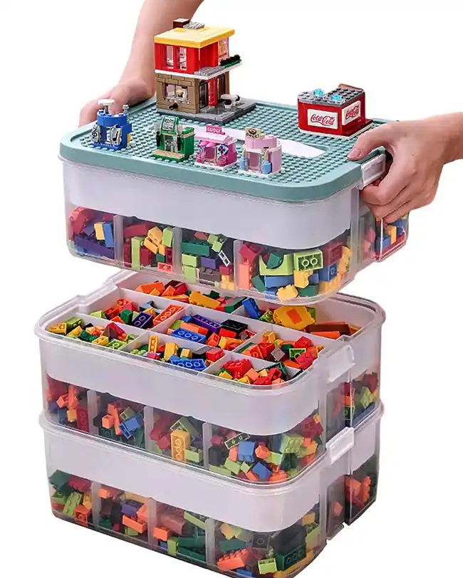 A stackable storage organizer with multiple compartments filled with Lego bricks, featuring a building surface on the top, providing an efficient and organized storage solution for building blocks.