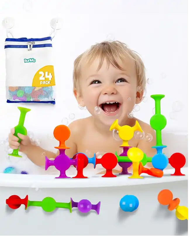 A cheerful baby playing with vibrant, flexible suction bath toys in a variety of colors and shapes, designed to stick to the tub walls and each other, encouraging imaginative play.