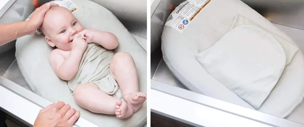 A baby being bathed in the Boon Puff+ Inflatable Baby Bather, showing the baby comfortably laying in the baby bath tub with a supportive backrest.