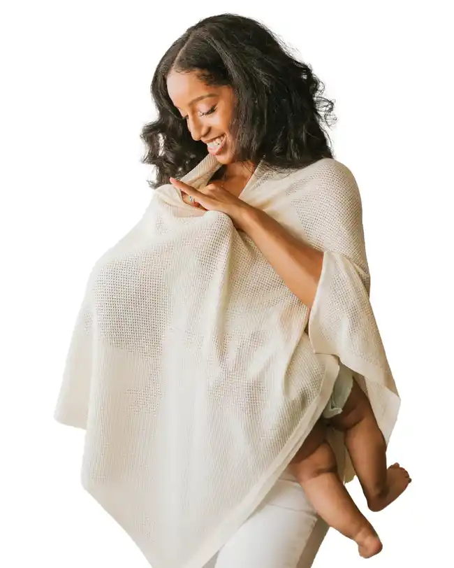 A mother using the Gold Mamas Nursing Cover, a soft and breathable knitted fabric cover, to breastfeed her baby comfortably and privately.