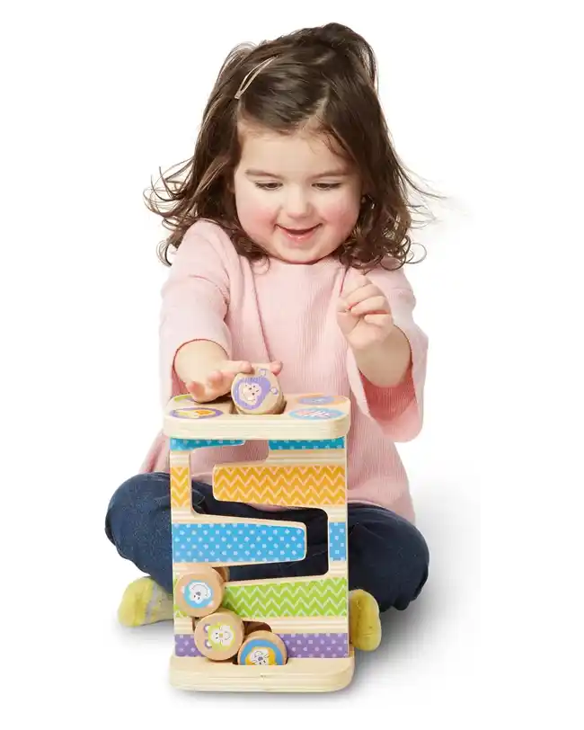 A toddler playing with a wooden zig-zag tower, watching wooden discs roll down, enhancing hand-eye coordination and understanding of cause and effect, perfect for Montessori toys for 1 year olds.