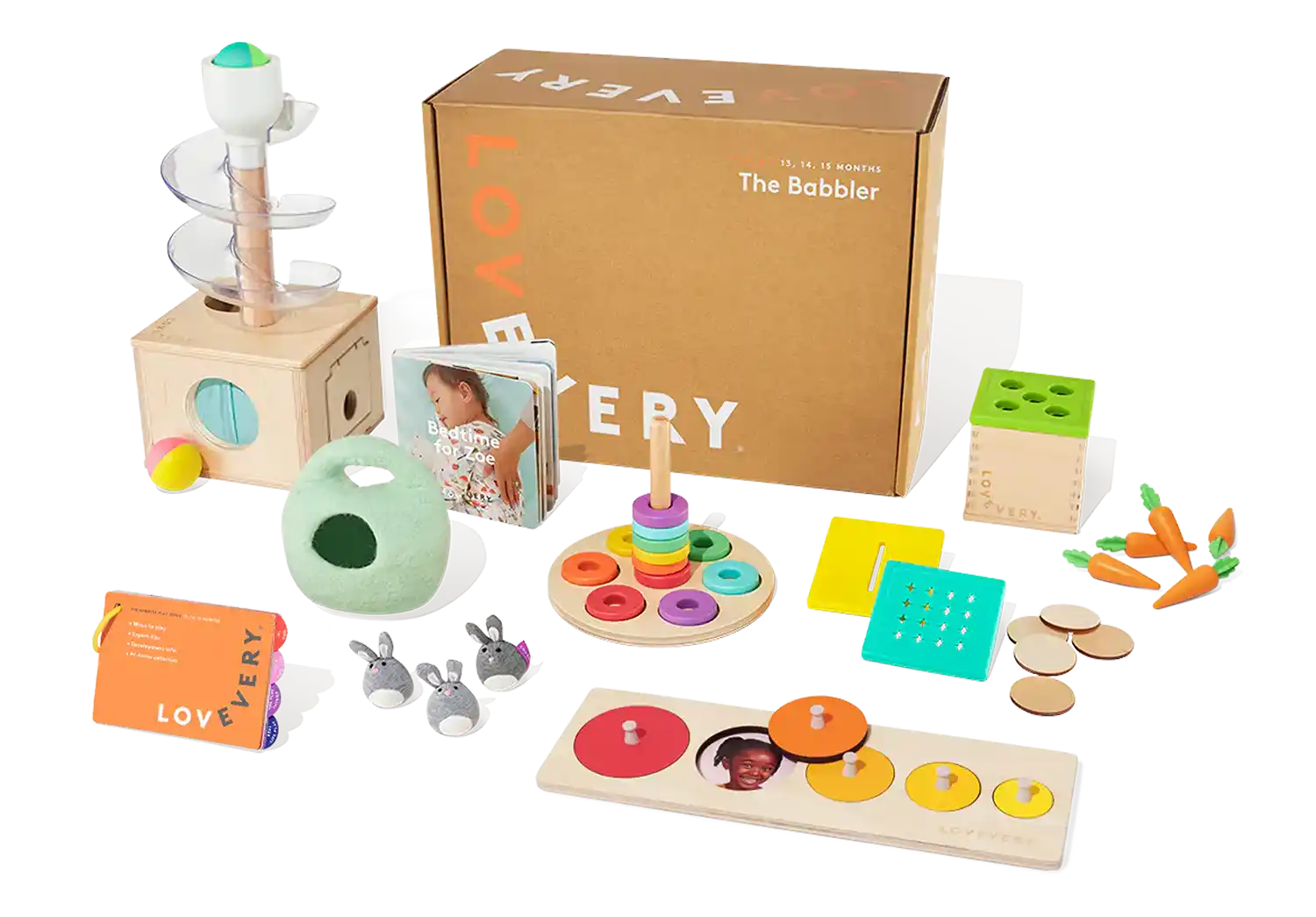 A collection of Montessori toys from Lovevery's The Babbler play kit, including a wooden ball drop tower, stacking rings, and books, ideal for Montessori toys for 1 year olds.