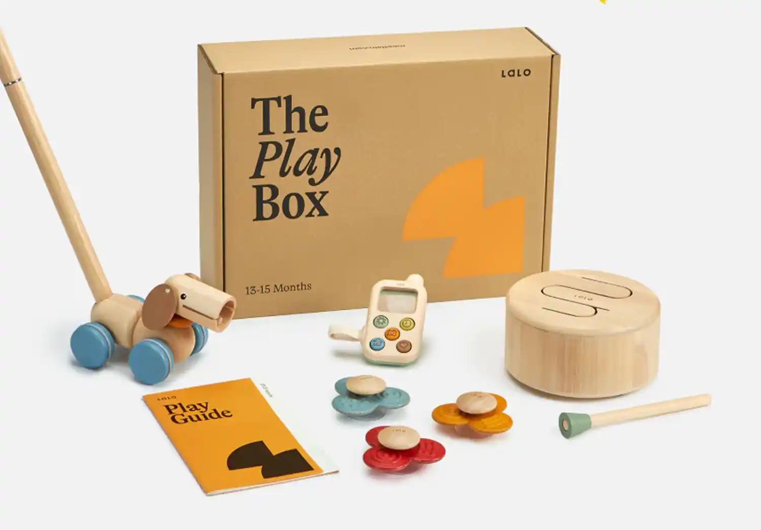 A selection of Montessori toys from Lalo's The Play Box, including a wooden push toy, stacking flowers, and a play guide, perfect for Montessori toys for 1 year olds.