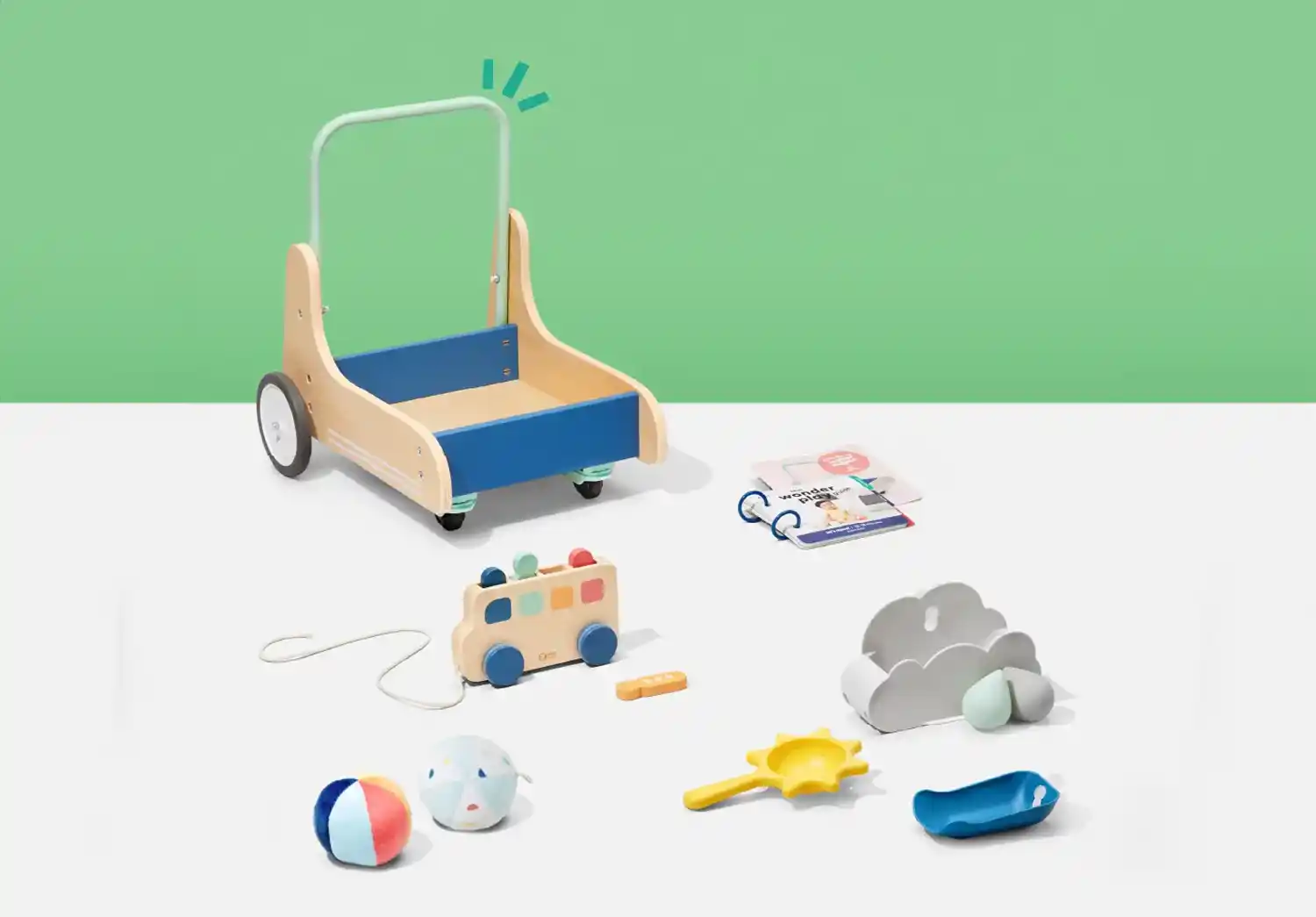 A variety of Montessori toys from KiwiCo's Panda Crate, including a wooden walker, pull toy, and soft balls, designed for 1 year olds to enhance their development.