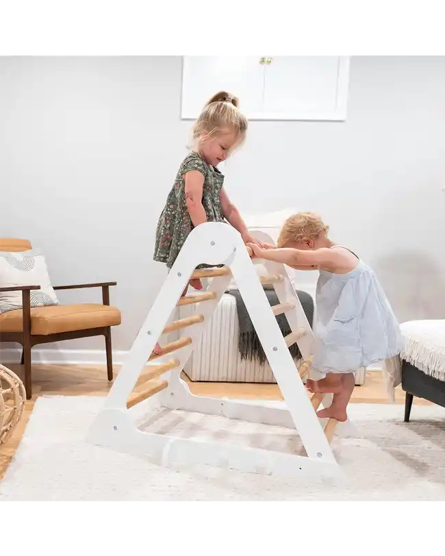 Two toddlers playing on a white and wooden climbing triangle, promoting gross motor skills and balance, perfect for Montessori toys for 1 year olds.