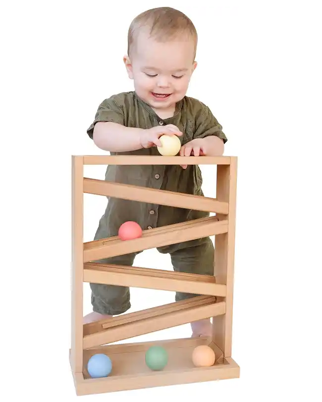 A wooden Montessori ball drop tower for 2 year olds, designed to teach cause and effect and improve hand-eye coordination.