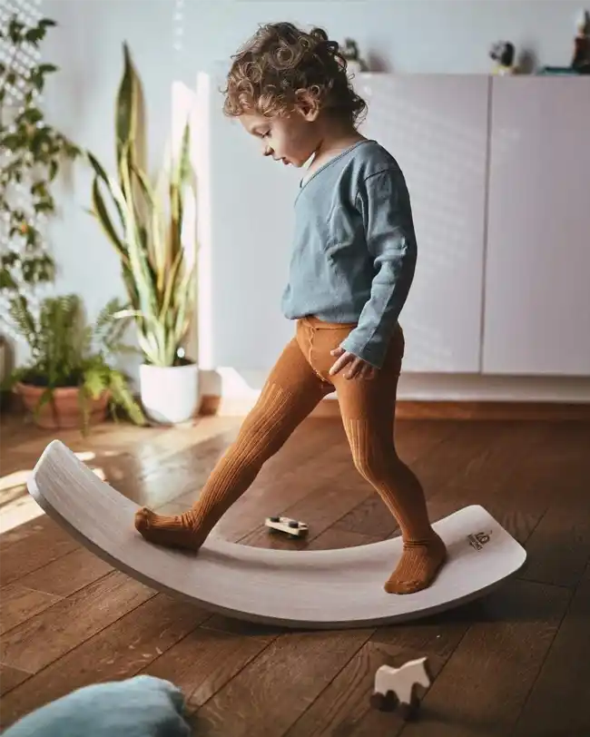 A wooden Montessori balance board for 2-year-olds, designed to develop core strength and balance.