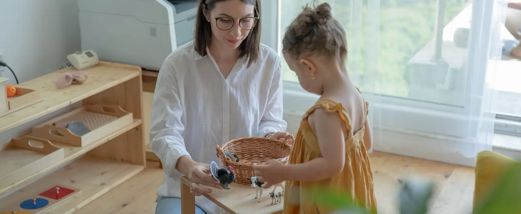 A parent and child engaging in a Montessori activity with animal figures, perfect for fostering learning and bonding with Montessori toys for 2 year olds