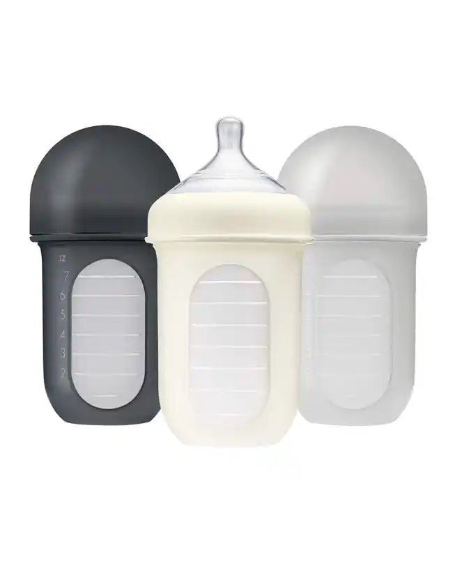 A set of Boon bottles, an infant travel essential designed for easy cleaning and reduced colic during travel.