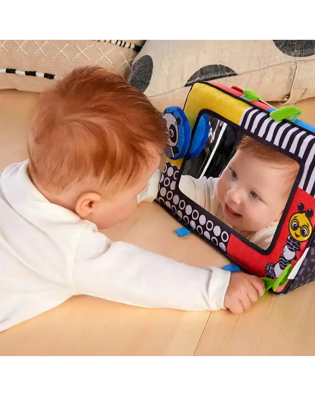  A baby engaging with the Baby Einstein Flip For Art High Contrast Floor Activity Mirror during tummy time, promoting visual development.