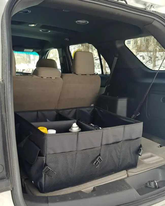 A collapsible trunk organizer in the back of an SUV, storing car essentials like cleaning supplies and safety gear, maximizing trunk organization.