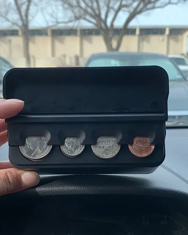 A coin holder keeping loose change neatly stored and organized in the front seat for quick access, contributing to effective car organization.