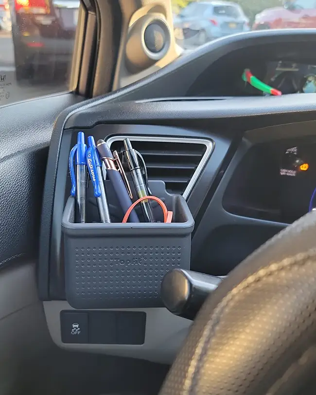  A vent pouch organizer holding pens and other small items, keeping the front seat tidy and boosting car organization.