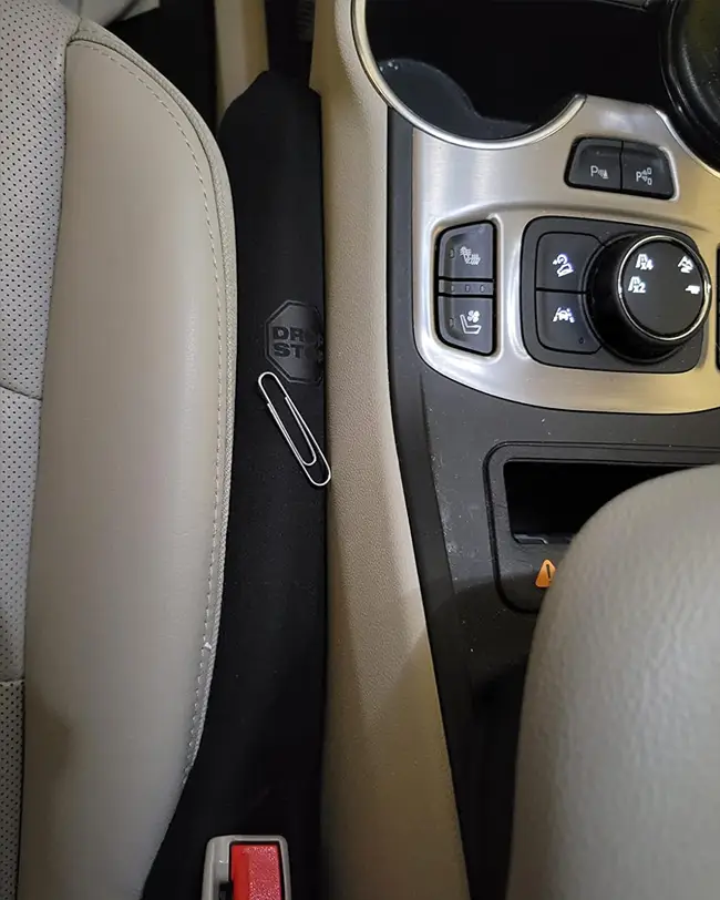 Drop Stop seat gap filler installed in the space between the car seat and center console, preventing items from falling through and improving car organization.