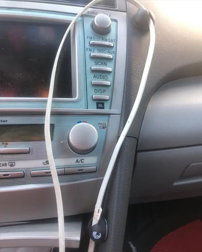 Magnetic cable holders attached to a car dashboard, ensuring neat cable management and contributing to better car organization.