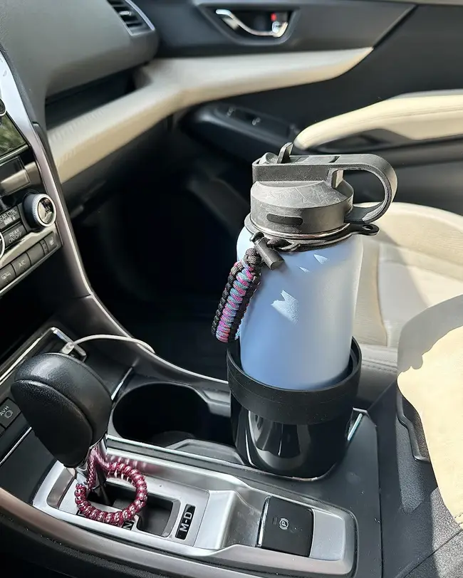 An extended cup holder in a car console securely holding a large water bottle, an essential for car organization and avoiding spills.