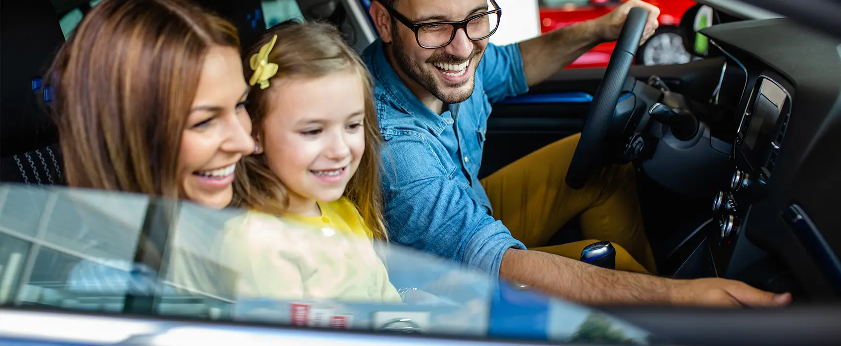 A family smiling inside a clean and organized car, showcasing the benefits of effective car organization for family trips.