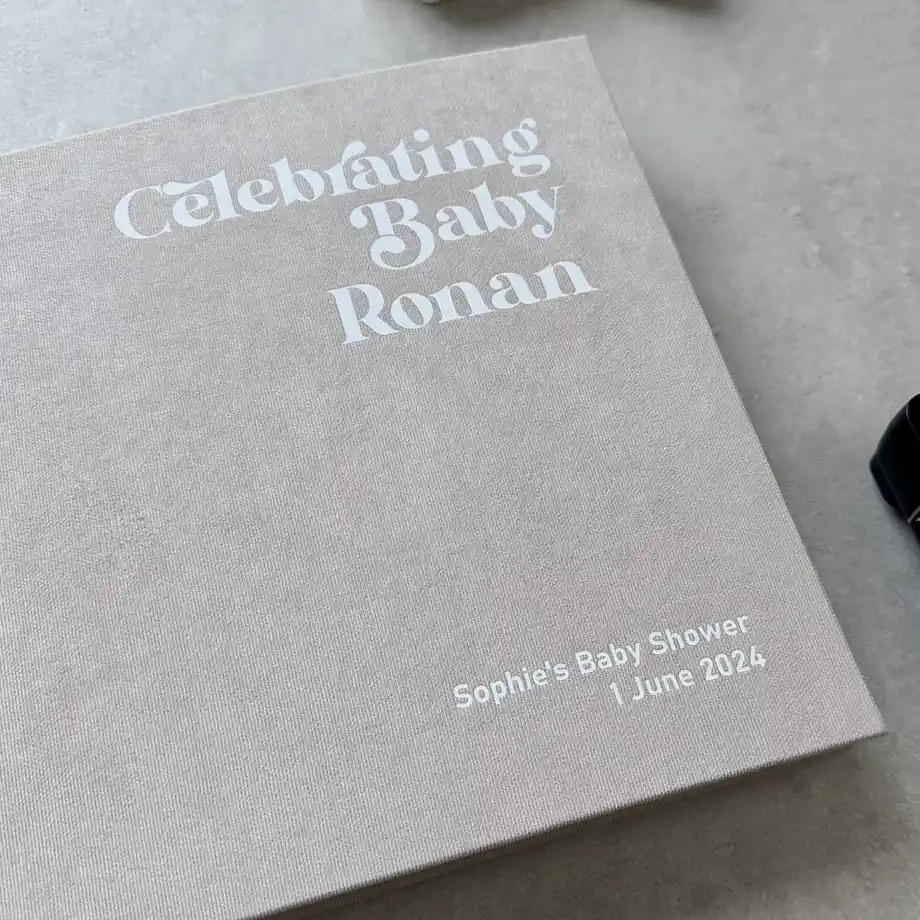 Minimalist baby shower guest book with 'Celebrating Baby Ronan' embossed on the cover, a keepsake from Sophie’s baby shower.