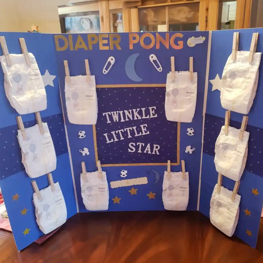 A "Twinkle Little Star" diaper pong game board featuring starry decorations and hanging diapers for a celestial baby shower game.