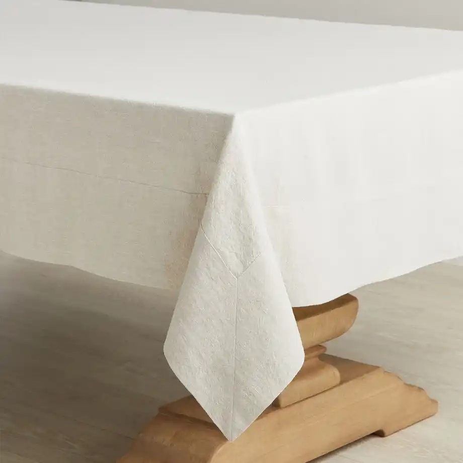 A natural linen tablecloth draped over a wooden table, a timeless and practical 12-Year Anniversary Gift.