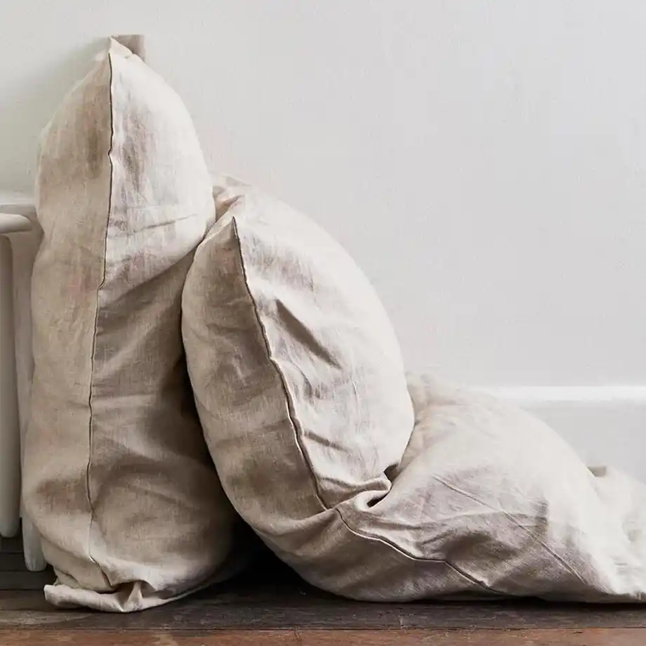 Natural linen throw pillows stacked casually, showcasing a cozy and thoughtful 12-Year Anniversary Gift idea.