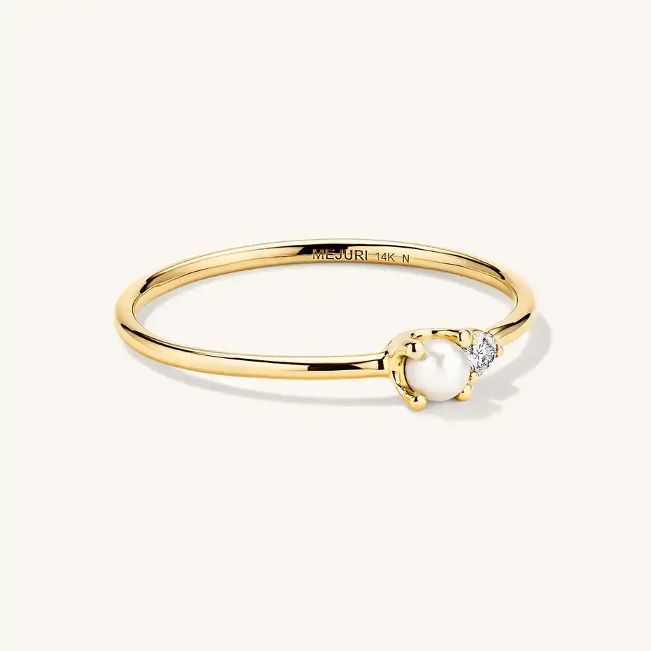 A delicate gold ring featuring a single pearl and diamond accent, a dazzling 12-year anniversary gift.