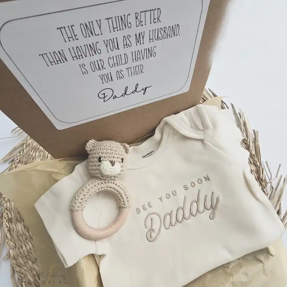 A thoughtful surprise box featuring an embroidered message, perfect for a heartfelt and creative pregnancy announcement idea for dads. A memorable way to share your exciting news.