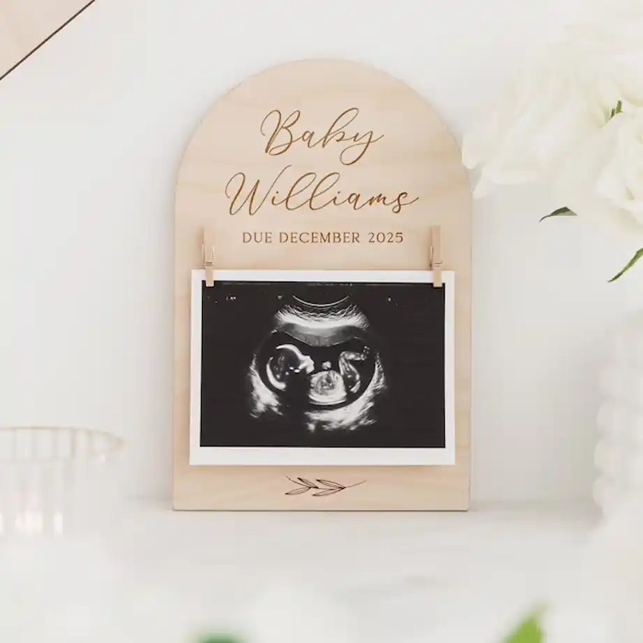 A beautifully crafted personalized wooden sign for pregnancy announcements, featuring baby details and surrounded by natural decor, ideal for creative and memorable pregnancy announcement ideas.