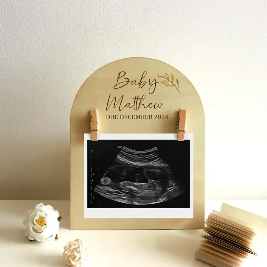 A personalized ultrasound photo prop featuring custom text and a sleek design, perfect for heartfelt and creative pregnancy announcement ideas to share the exciting news with loved ones.