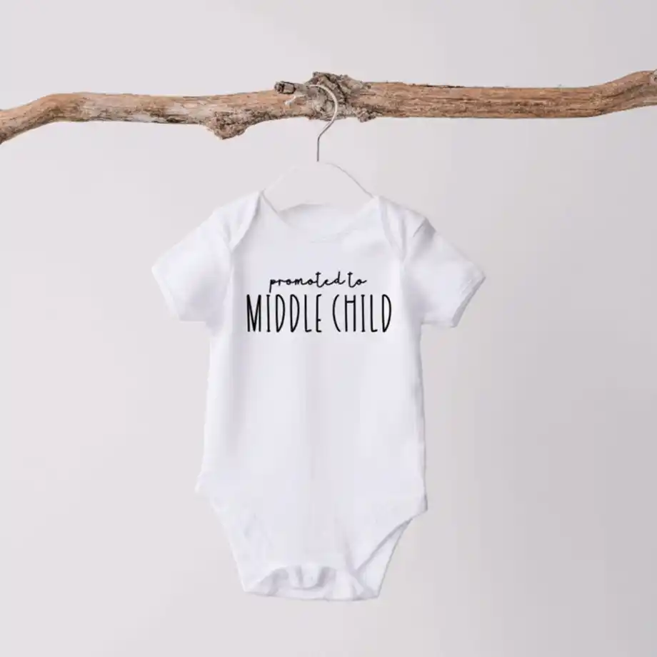 Reveal your pregnancy in a fun way with this 'Promoted to Middle Child' onesie, perfect for announcing the arrival of your second child. A unique and playful pregnancy announcement idea!